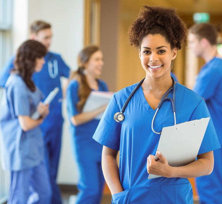 Medical Staffing Coordinator in hospital with nurses in the background